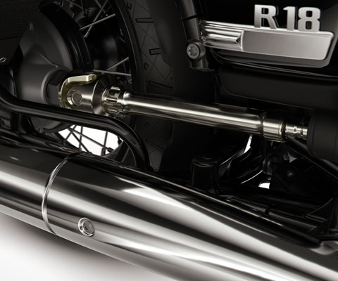 We see the round exhaust pipe, the open drive shaft, and the double cradle frame.
